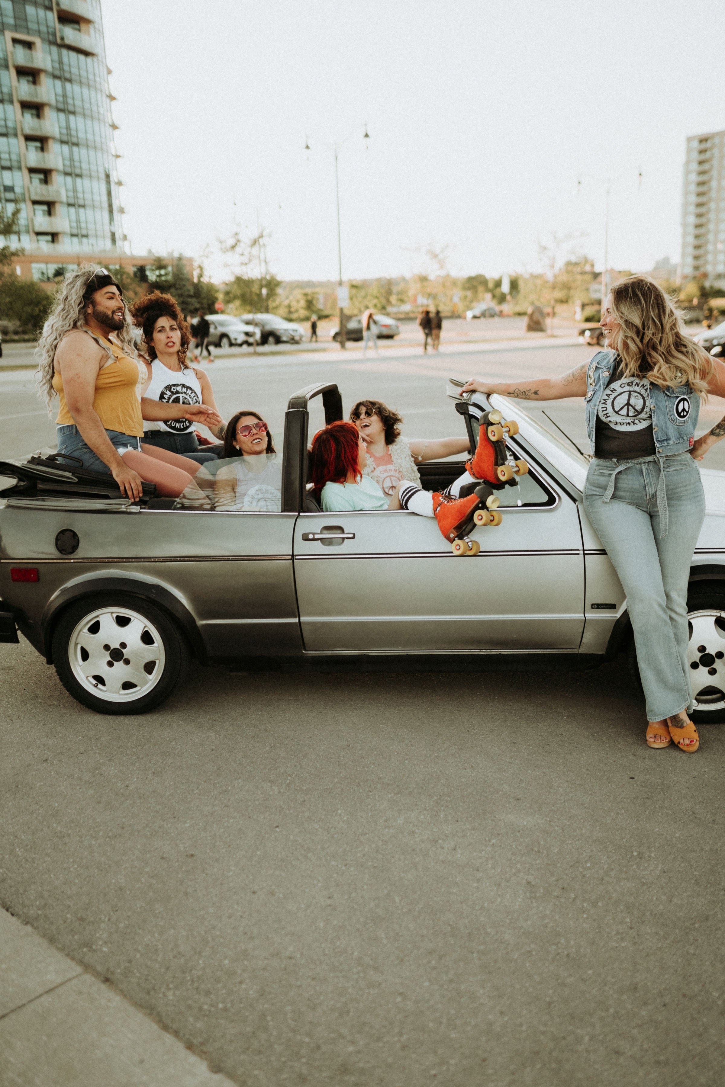 Group including Heather sitting a car with Human Connection Junkie apparel